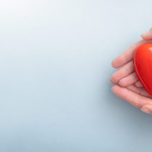 The woman is holding a red heart. Concept for charity, health insurance, love, international cardiology day.