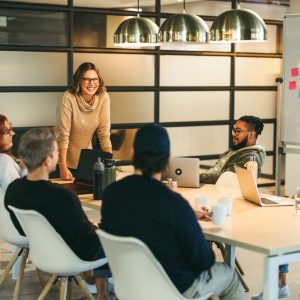 Business people in a boardroom are engaged in a lively discussion. They work together as a team, brainstorming creative ideas for a successful tech company project. Guided by a confident leader, their collaboration fosters a professional and innovative workplace environment.